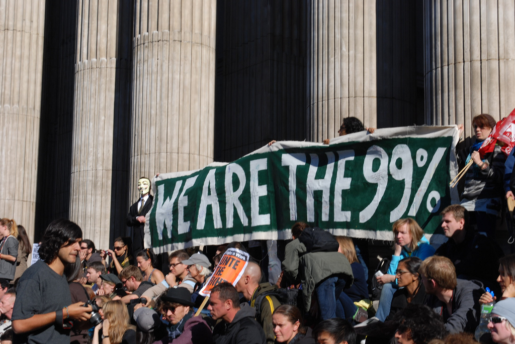 Protesters holding up sign reading "we are the 99%"