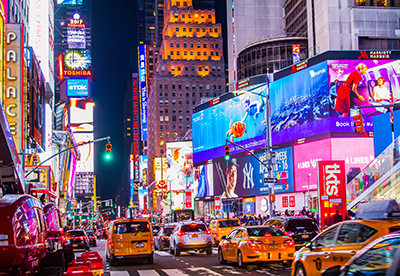 Times square in New York and night filled with illuminated advertising signage.