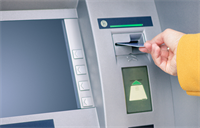 Hand inserting bank card into automatic teller machine