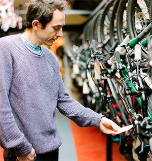 Man looks at price tag on bicycle in shop