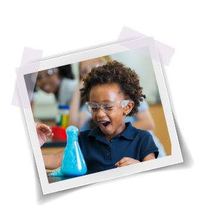 Young child in a class excited over blue liquid bubbling out of a beaker.