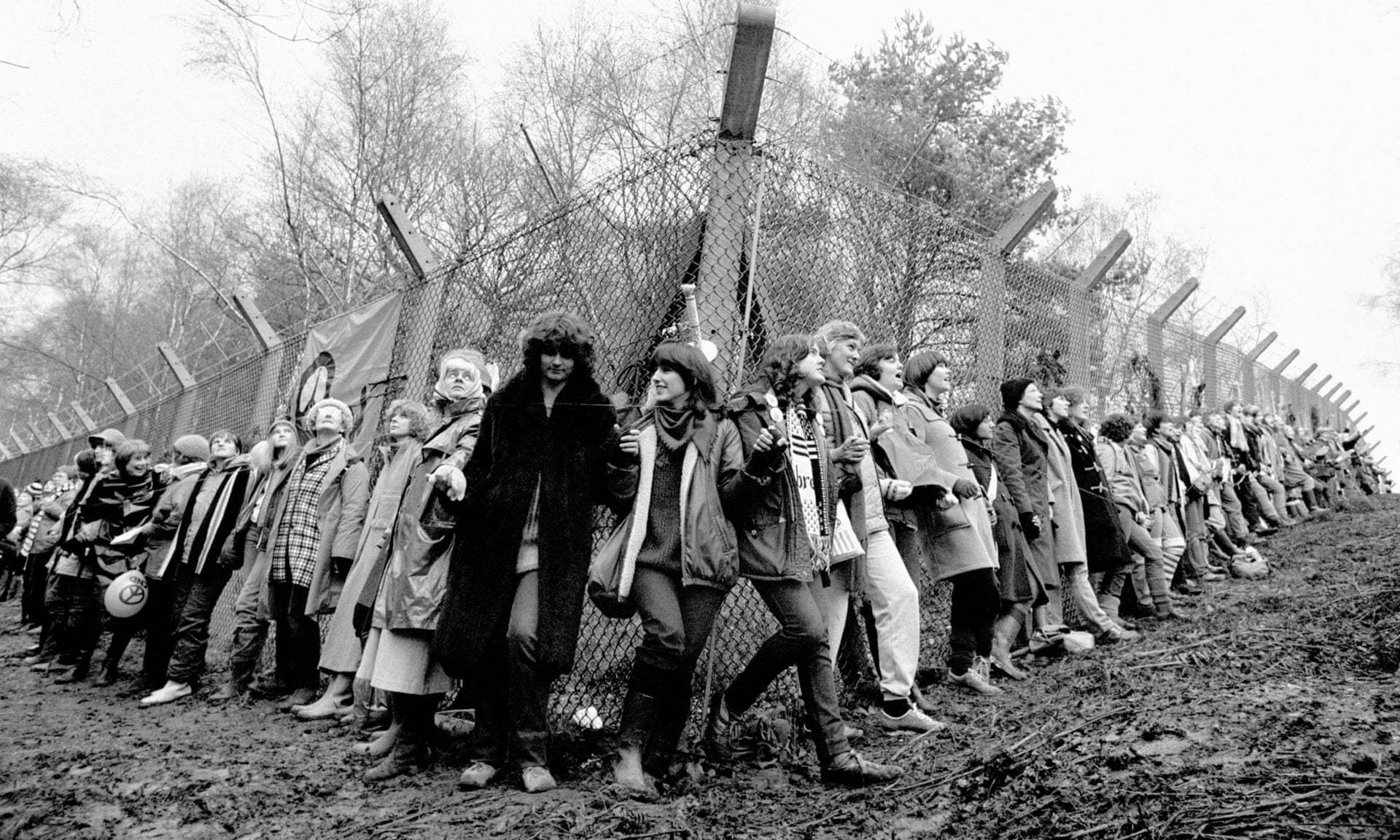 Women with linked hands around Greenham Commons fence