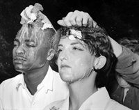 Two nonviolent people training, with eggs being cracked on their heads