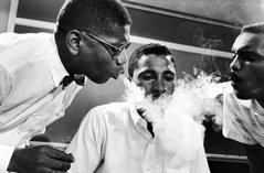 Two nonviolent people training, with smoke being blown in their face