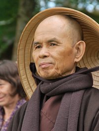 portrait of Thích Nhất Hạnh holding a bell